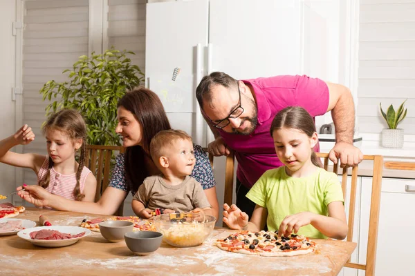 Die jungen Eltern kochen mit ihren kindern — Stockfoto