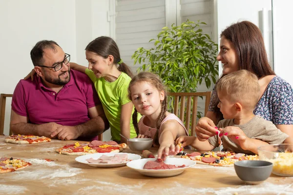 젊은 가족 이 집에서 함께 피자를 준비 한다 — 스톡 사진