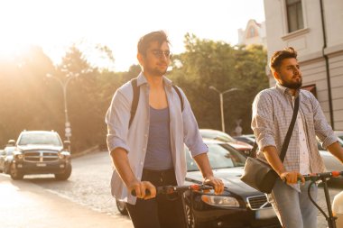 Şehirde elektrikli scooterları olan iki yetişkin öğrenci var.