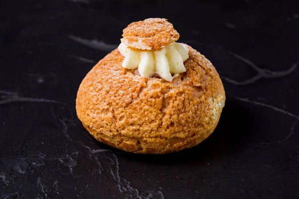 One choux cake with whipped cream on the black — Stock Photo, Image