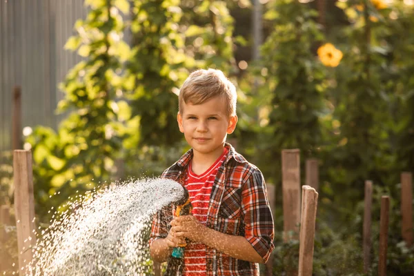Il bambino innaffia le piante facendo grandi spruzzi d'acqua — Foto Stock