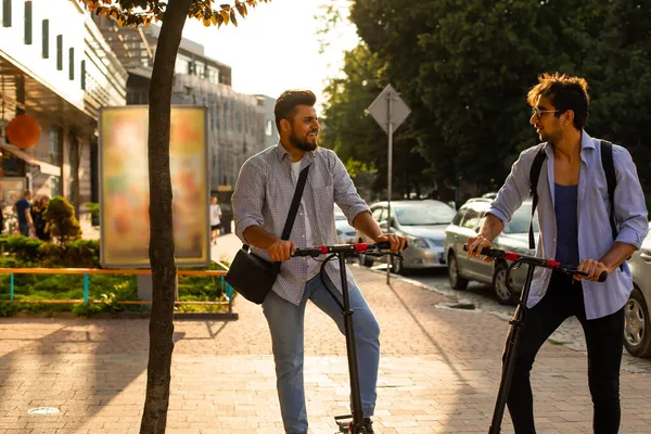 2.两个骑电动车的成年学生站在城里 — 图库照片
