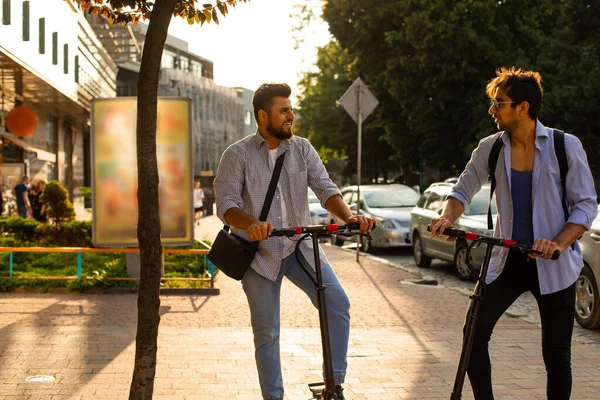Şehirde elektrikli scooterları olan iki yetişkin öğrenci var.