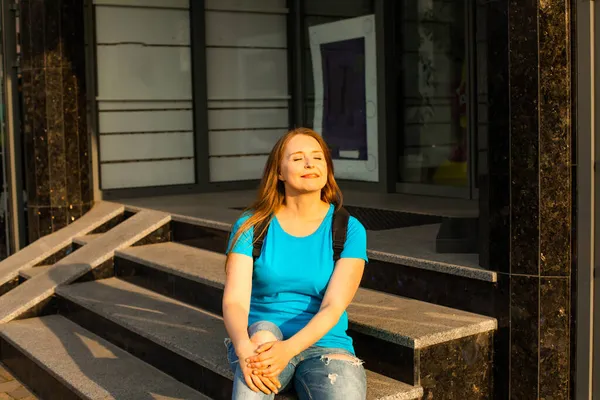 La estudiante feliz en ropa casual está posando en la ciudad — Foto de Stock