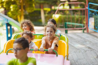 Lunaparktaki lunaparkta hız trenindeki mutlu çocuklar.