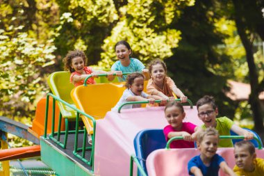 Çocuklar lunapark trenine binerken harika duygular hissederler.