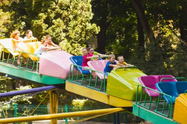 Çocuklar lunapark trenine binerken harika duygular hissederler.