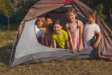Çocuklar yaz kampında doğada dinleniyorlar.