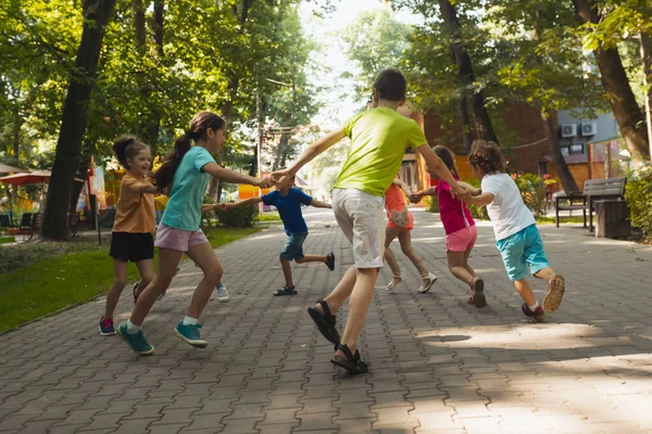 Szczęśliwe dzieci bawią się w parku. — Zdjęcie stockowe