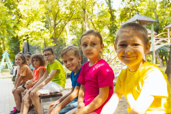The group of children are resting in the summer park — Stock Photo, Image