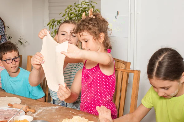 Die kleine Kindergruppe kocht gemeinsam Pizza — Stockfoto