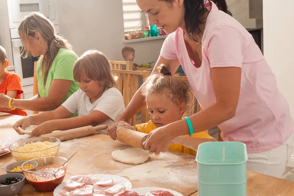 Los educadores junto con los niños en edad preescolar hacen pizza —  Fotos de Stock