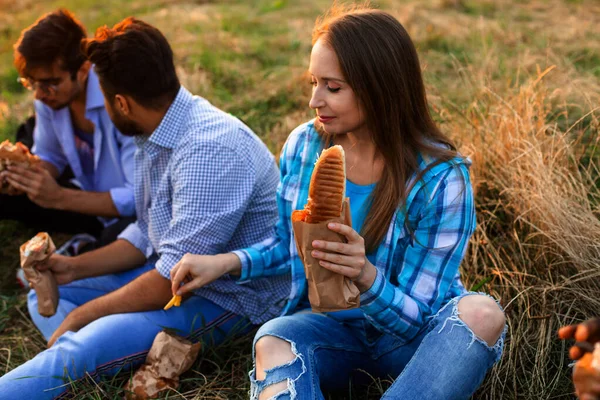 De unga multietniska studenterna äter snabbmat på campus — Stockfoto