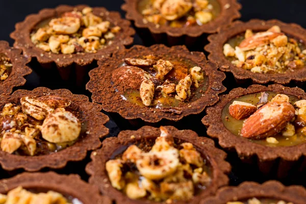 Вкусные шоколадные тарталетки с карамельным кремом и орехами — стоковое фото