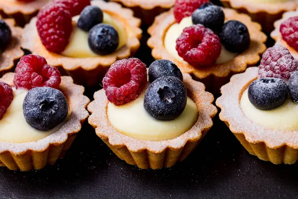 Cerrar deliciosos tartalets de arándanos con crema de vainilla — Foto de Stock