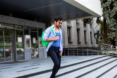 Kendine güvenen öğrenci üniversite binasını terk ediyor.