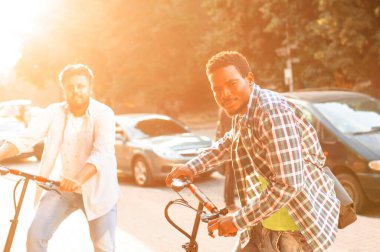 Şehirde elektrikli scooterları olan iki yetişkin öğrenci var.