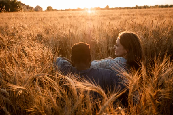 Abbracciare coppia incontro tramonto in un campo di grano — Foto Stock