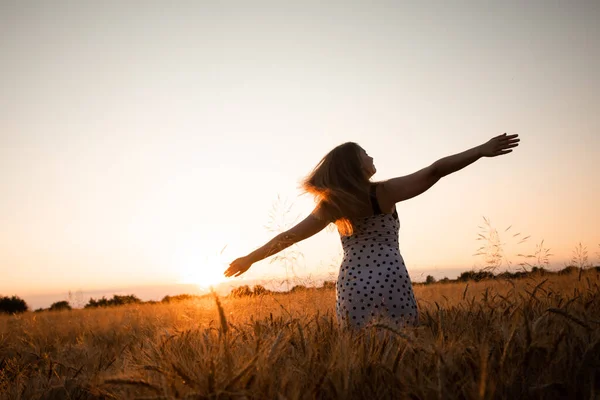 Mujer pacífica que recibe el sol naciente en el campo — Foto de Stock