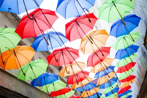 Şehirdeki caddenin tepesindeki renkli şemsiyeler. — Stok fotoğraf