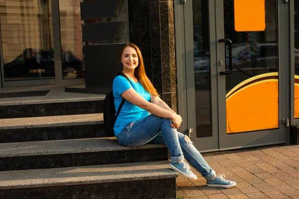 La estudiante feliz en ropa casual está posando en la ciudad — Foto de Stock