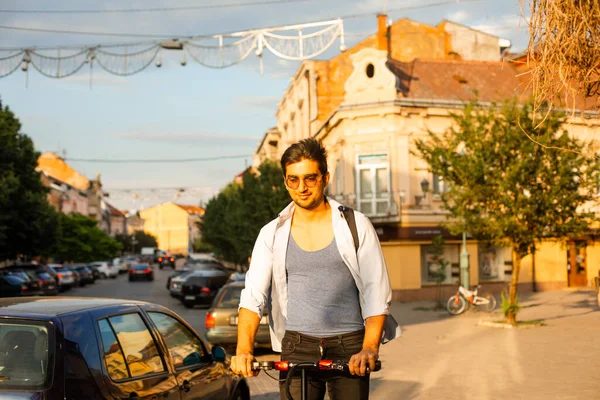 Szczęśliwy student jeździ skuterem elektrycznym w mieście — Zdjęcie stockowe