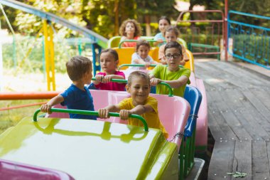 Lunaparktaki lunaparkta hız trenindeki mutlu çocuklar.