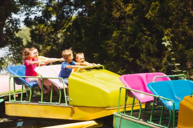 Çocuklar lunapark trenine binerken harika duygular hissederler.
