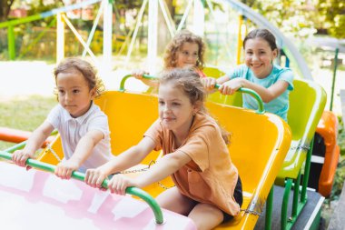 Çocuklar lunapark trenine binerken harika duygular hissederler.