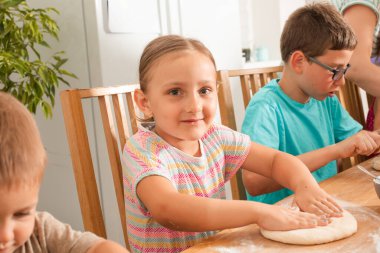 Anaokulu öğrencileri ev yapımı pizza yapmaktan memnunlar.