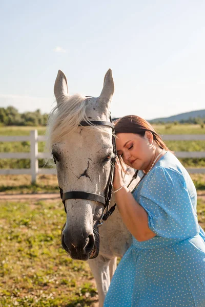 La femme aux cheveux bouclés se blottit sur son cheval — Photo