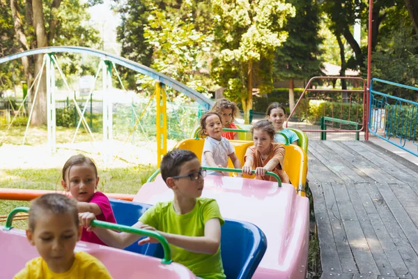 Los niños pequeños felices están descansando en el parque de atracciones —  Fotos de Stock
