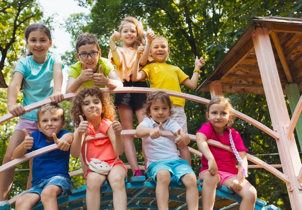 The little kids in the playground are showing thumbs up — Stock Photo, Image
