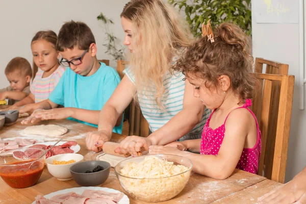 O professor está aprendendo as crianças a cozinhar pizza — Fotografia de Stock