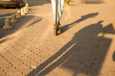 Genç adam elektrikli scooter kullanırken iyi bir ruh hali içinde.