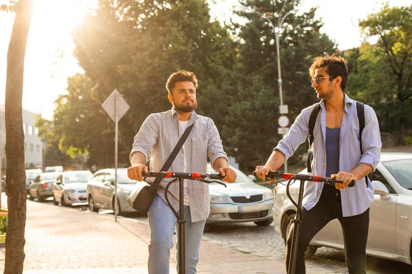 Şehirde elektrikli scooterları olan iki yetişkin öğrenci var.