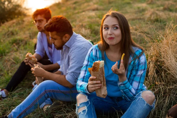 De unga multietniska studenterna äter snabbmat på campus — Stockfoto