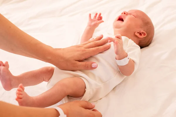 Mama robi masaż brzucha noworodkowi. — Zdjęcie stockowe