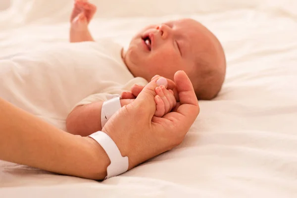 Newborn baby and mom are holding hands — Stock Photo, Image