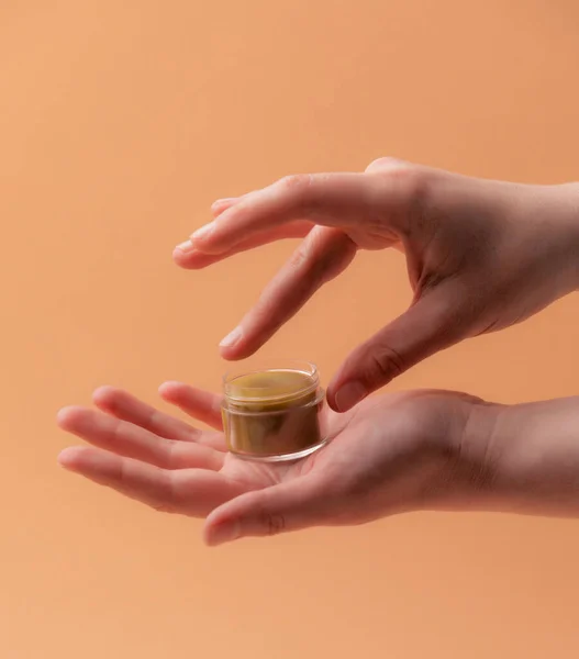 Natuurlijke eco lippenbalsem met vrouwelijke handen over beige — Stockfoto