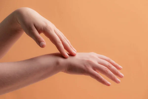 Tangan wanita muda mengoleskan krim atau lotion — Stok Foto