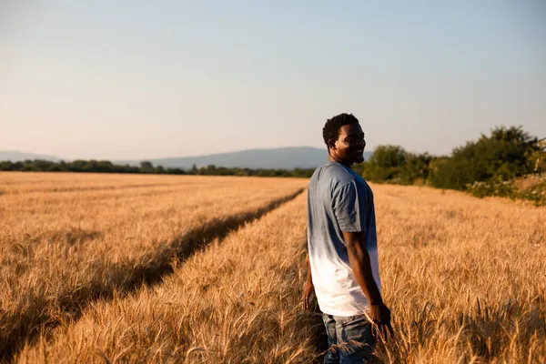 Jeune agriculteur debout au milieu du champ — Photo