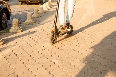 Genç adam elektrikli scooter kullanırken iyi bir ruh hali içinde.