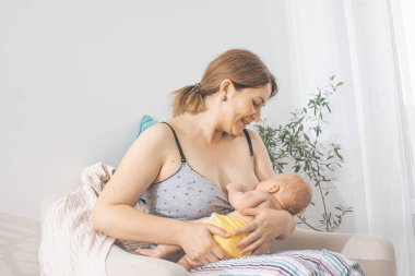 Genç anne yeni doğmuş bebeğini emzirmek istiyor.