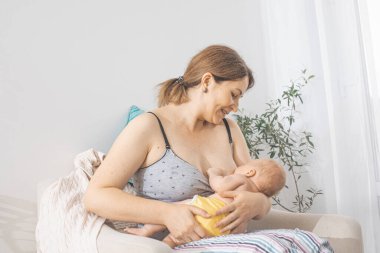 The young mom wants to breastfeed her newborn baby clipart