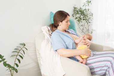 Genç anne yeni doğmuş bebeğini emzirmek istiyor.
