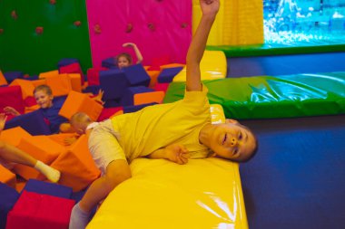 Trambolin parkındaki yorgun ve mutlu küçük çocuk.