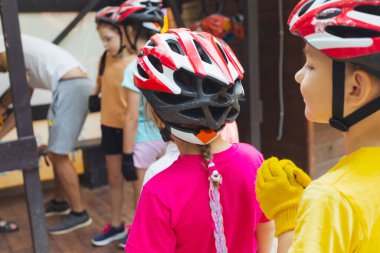 Çocuklar halat parkında güvenli bir tırmanışa hazırlanıyorlar.