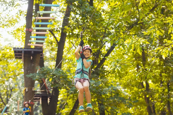 De kleine jongen gaat door de zipline in het park. — Stockfoto