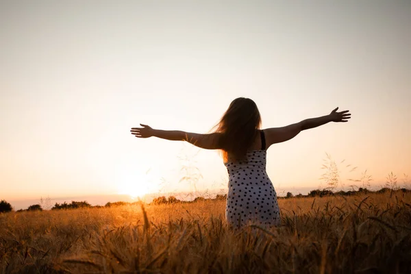 Peaceful woman wellcoming the rising sun in field — Stock Photo, Image